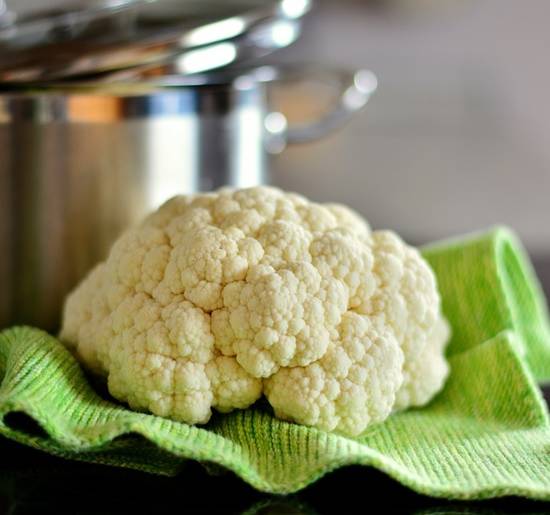 Een bloemkool die voor een pan ligt